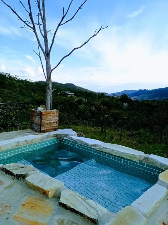 Piscina privativa com borda de pedra e vista para as montanhas